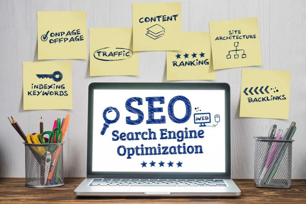 A laptop displaying SEO with sticky notes featuring key SEO terms like traffic, content, and backlinks