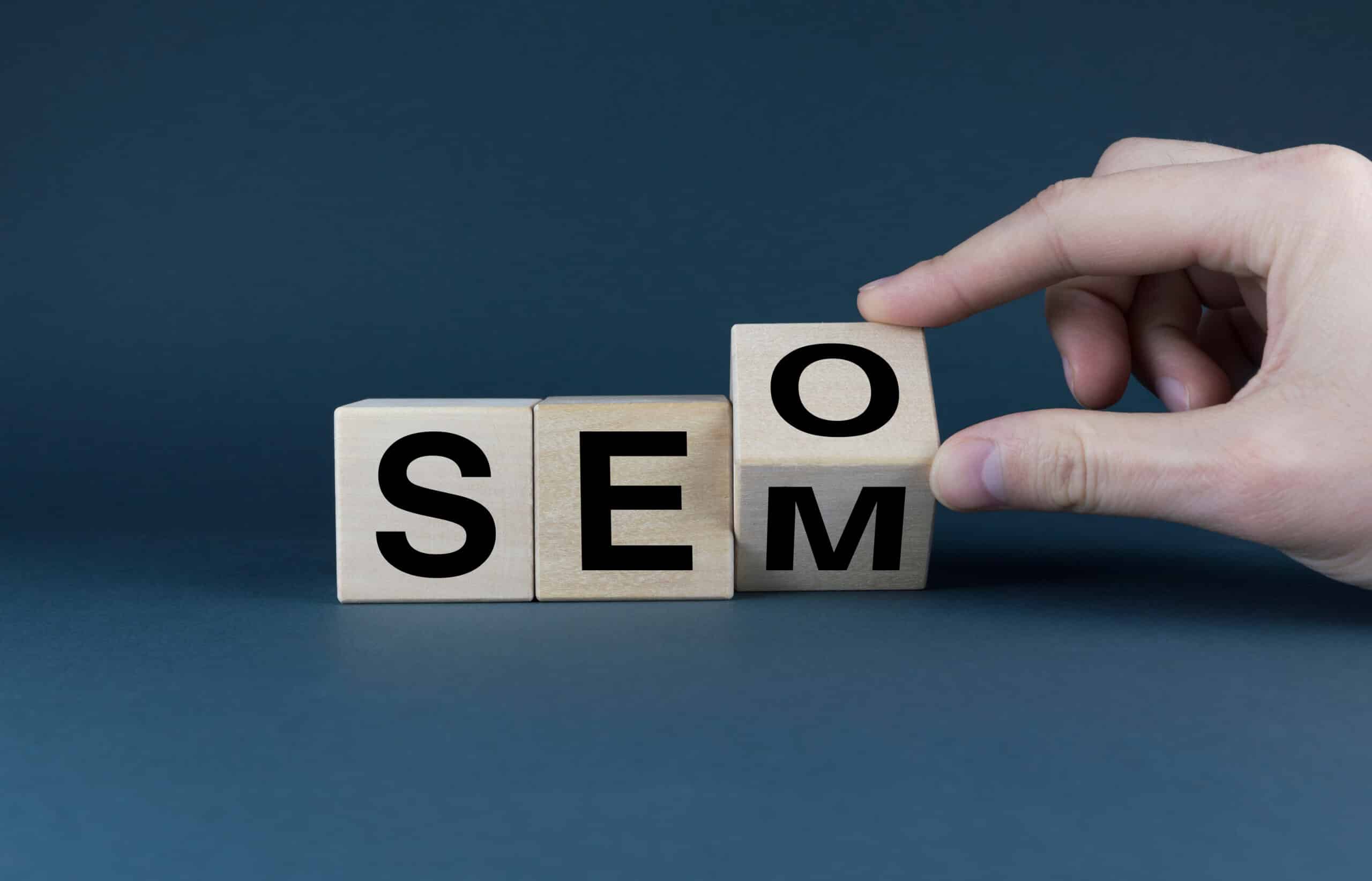 Hand changing wooden blocks from 'SEO' to 'SEM'