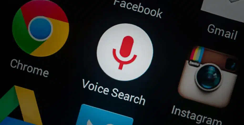 An image of a smartphone screen with the Voice Search icon highlighted.