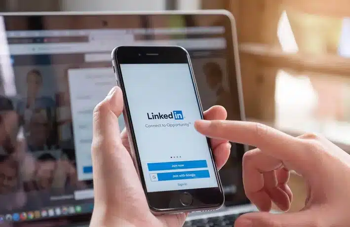 view of a person holding phone with linkedin app open