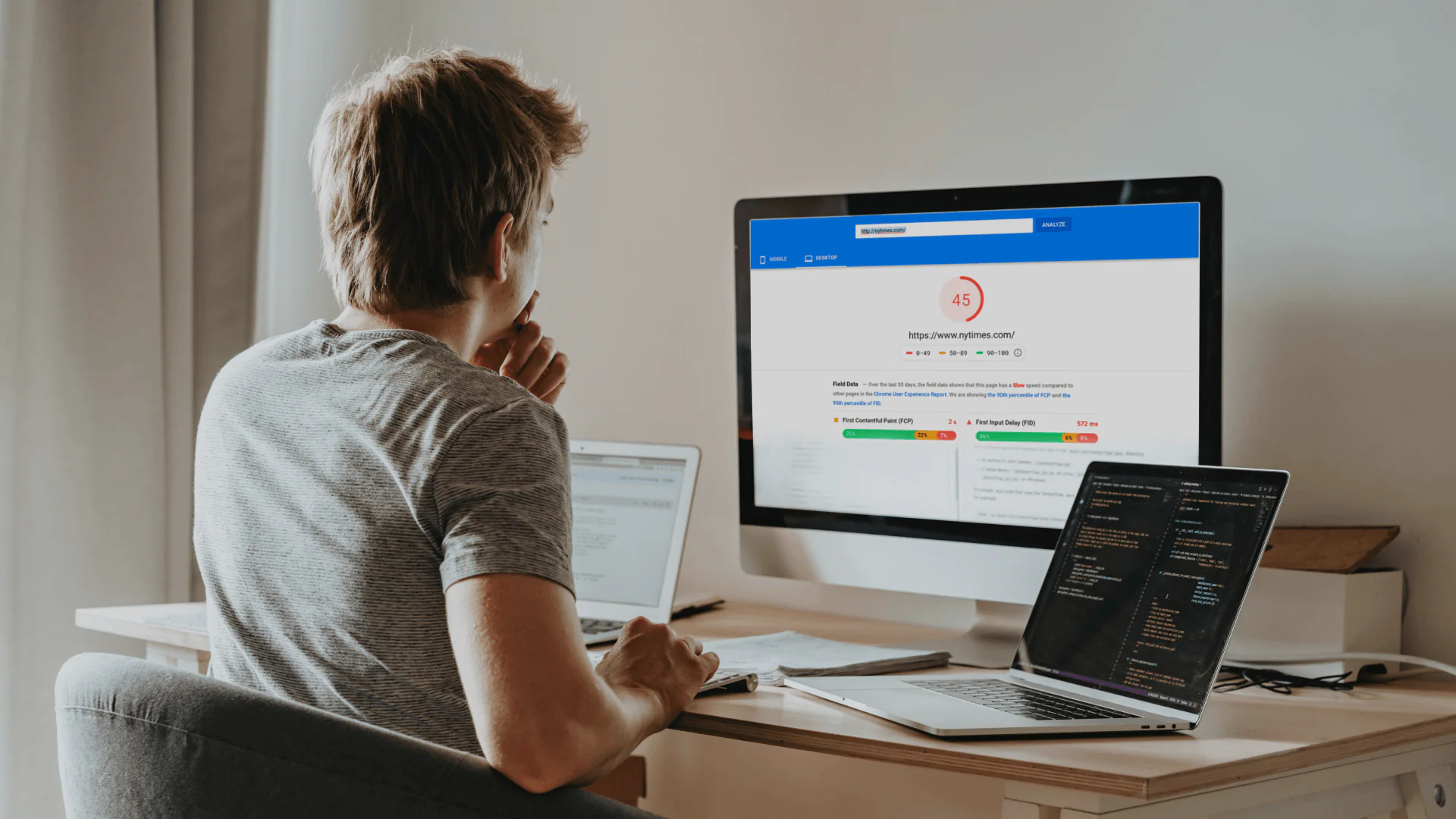 Person analyzing website performance metrics on a desktop computer with multiple screens. Person analyzing website performance metrics on a desktop computer with multiple screens.
