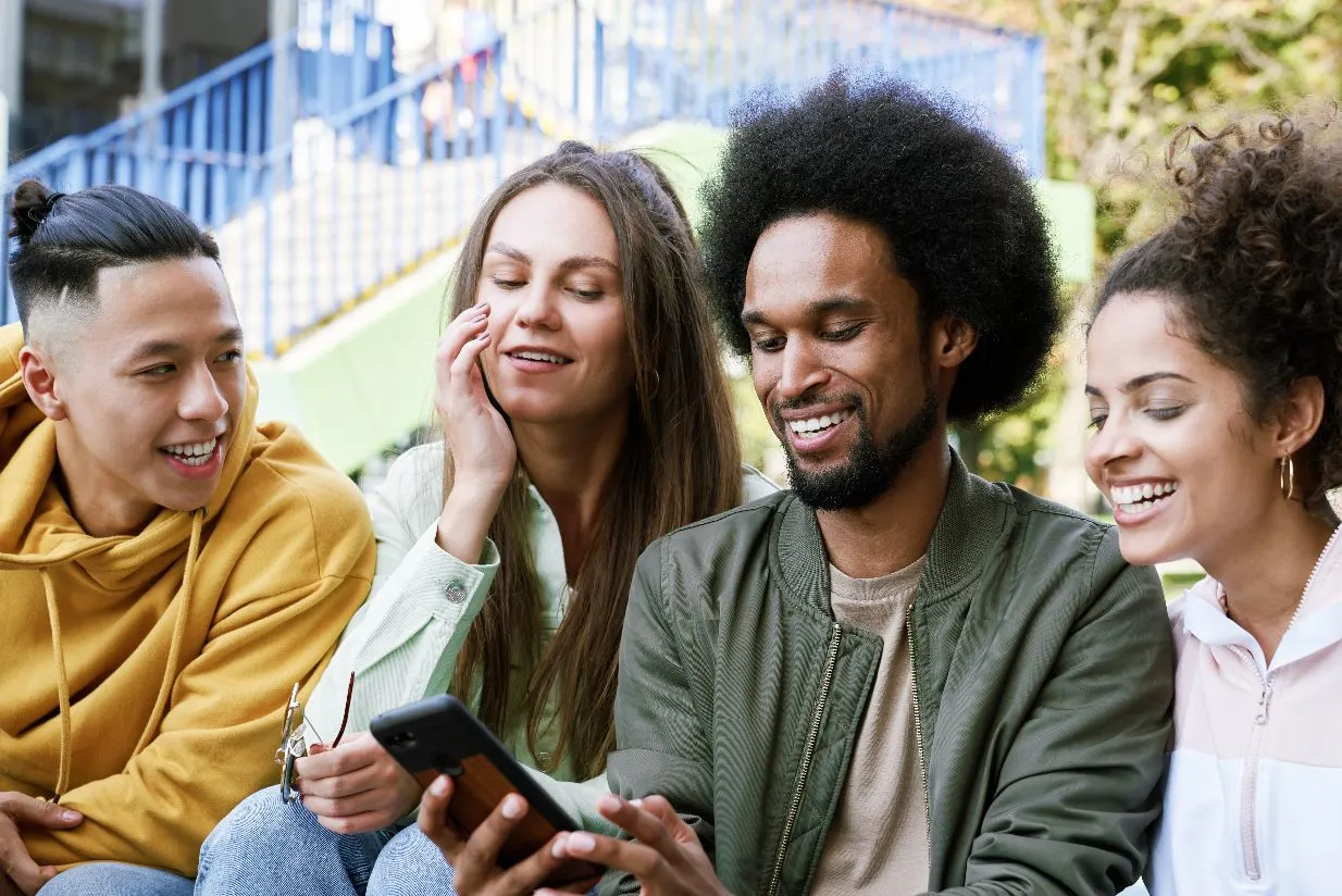 a group of people watching something on a smart phone