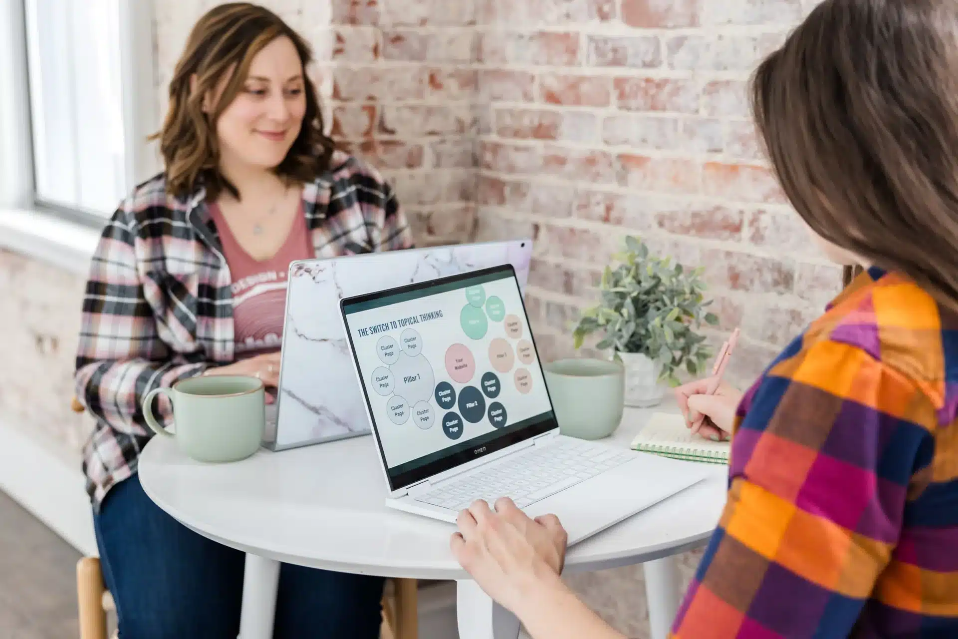 Content strategy team discussing topic clusters and planning ideas on a laptop