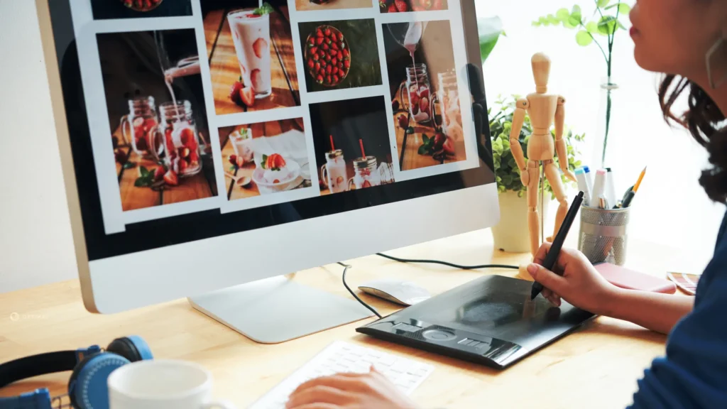  Designer working on website images and visual content using a graphic tablet and computer.