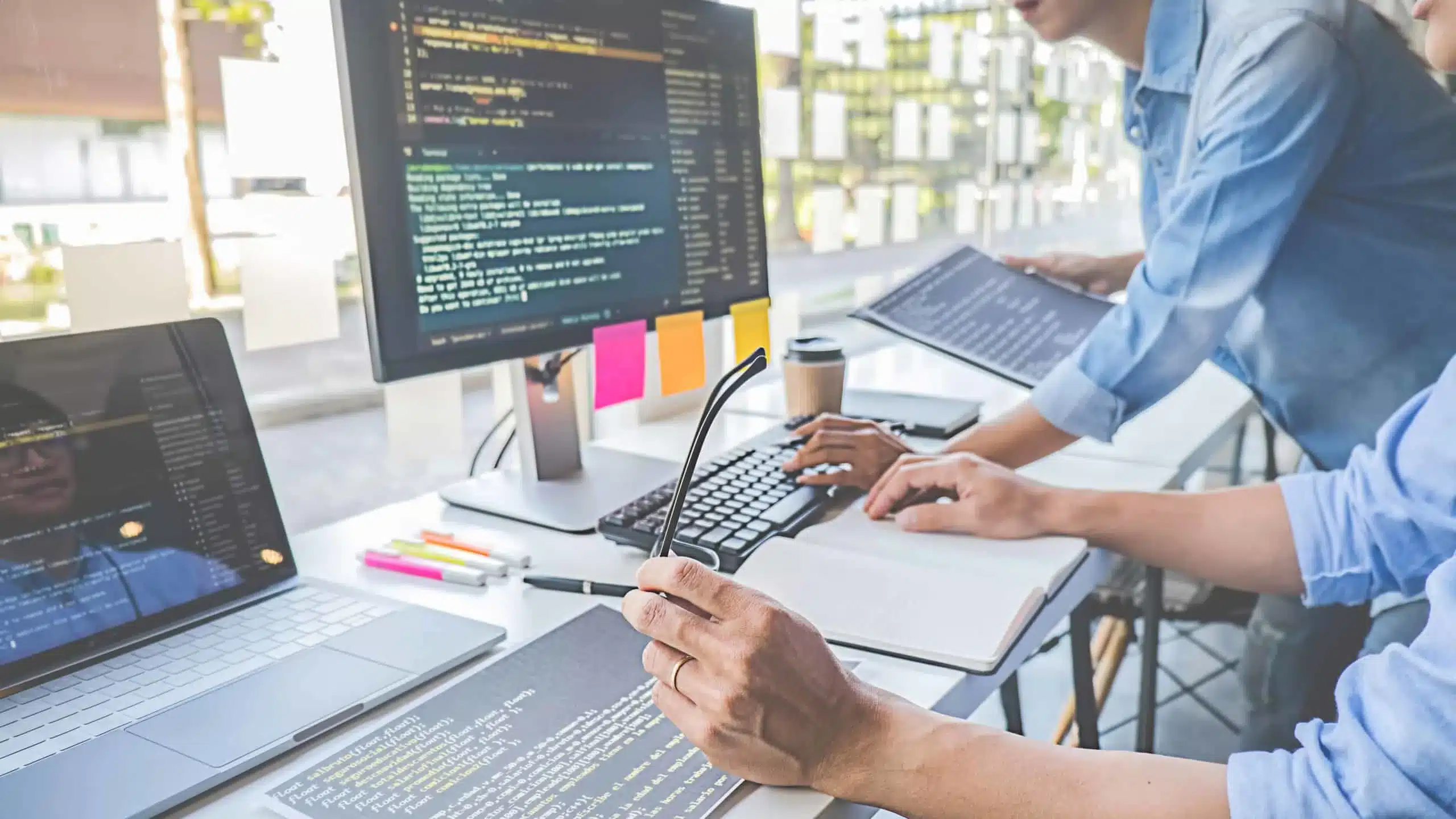 Developers coding and reviewing website code on computers